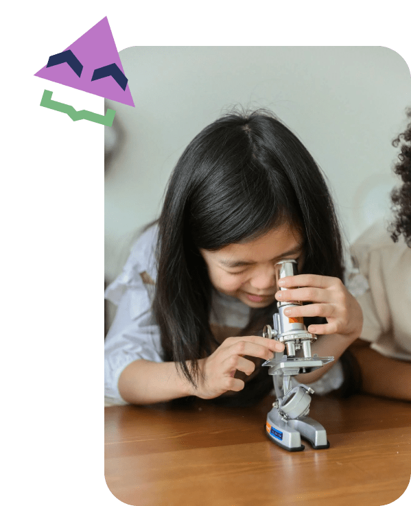 child looking through microscope